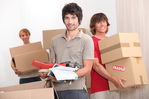 Removal team handling boxes and furniture in a Pimlico apartment move